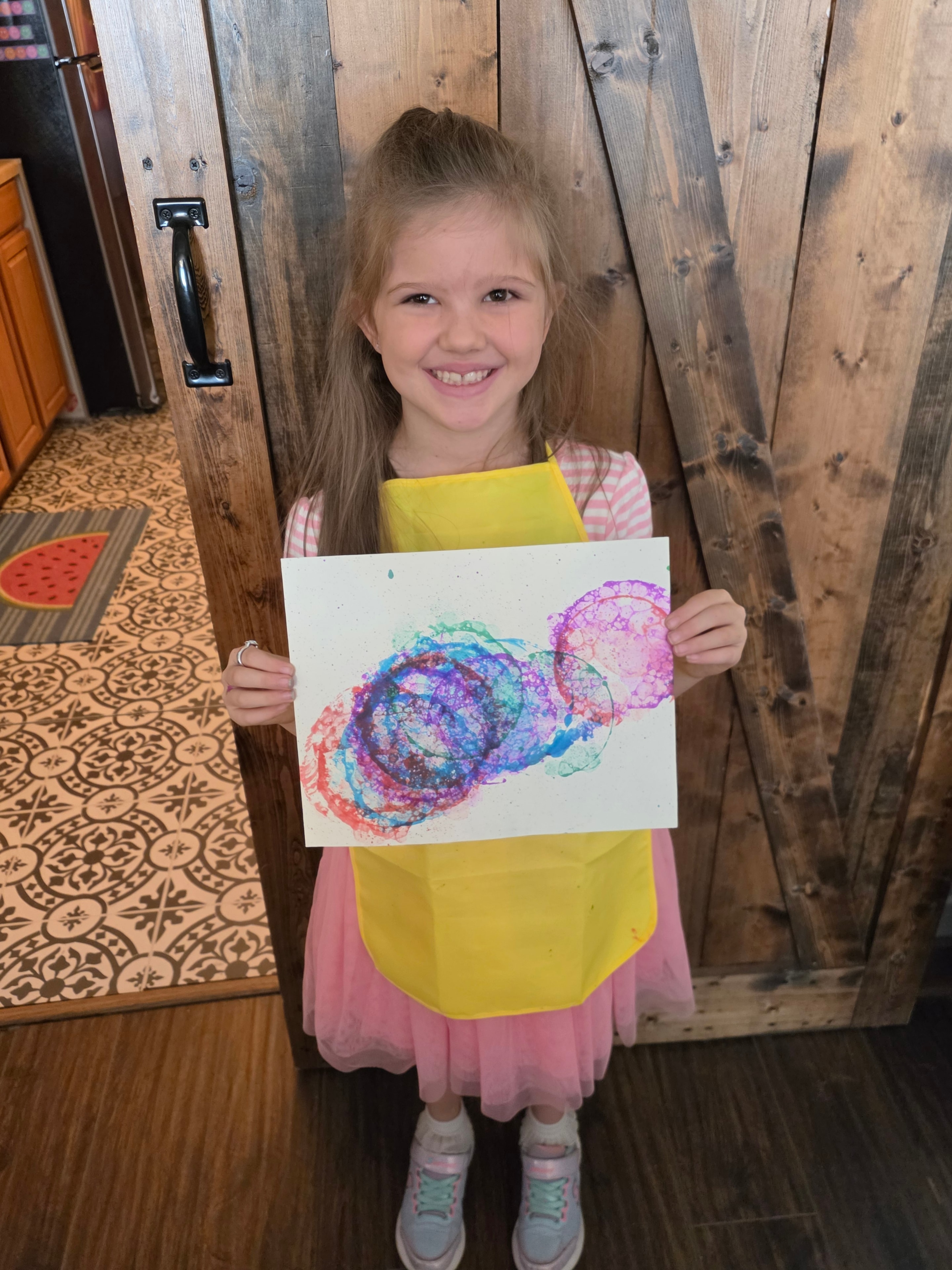 Student holding colorful bubble art painting at Focus Microschool